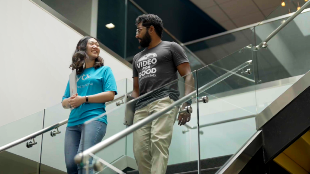 Lytx's Gloria and Krishna, who use AI and tech to help save lives, walk down stairs in the company's office.